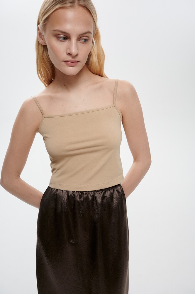 Прилегающий топ на тонких бретелях из мягкого хлопка станет минималистичным первым слоем для многослойного комплекта.