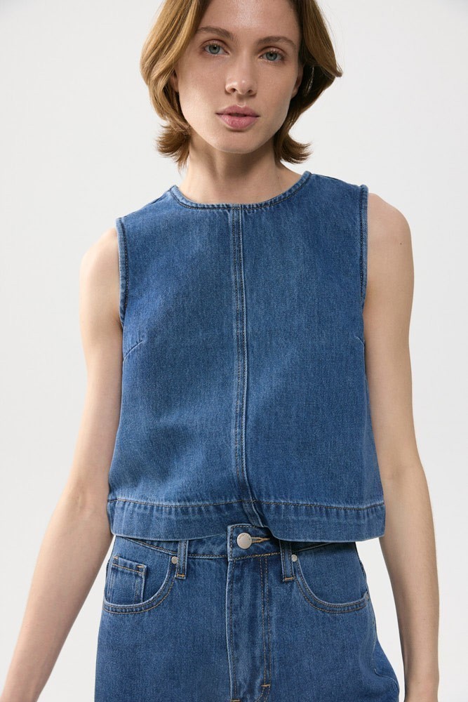 Графичный топ из тонкого денима. Благодаря своей длине поможет эффектно выделить талию и при этом создать актуальный расслабленный комплект.